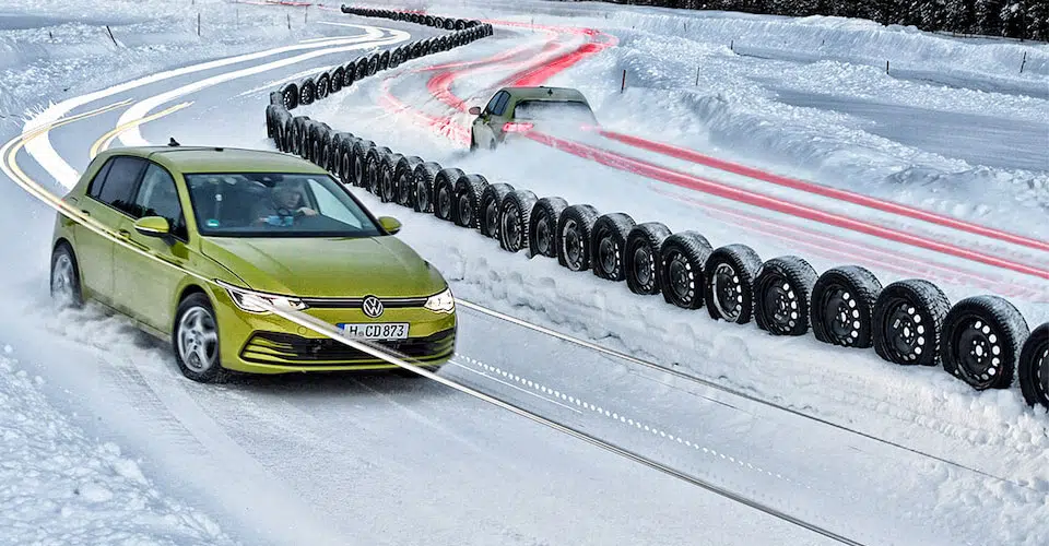 Volkswagen Golf circule sur un circuit enneigé et passe devant les 50 pneus hiver testés par Auto Bild pour son comparatif 2021
