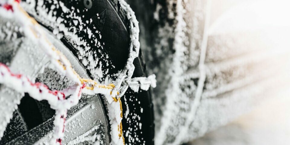 Pneu hiver avec des chaînes couvert de neige
